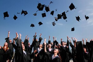A group of graduates in black gowns and caps, with some caps in mid-air, suggesting a graduation ceremony. - Staybridge Suites North - Albuquerque by IHG (Albuquerque)