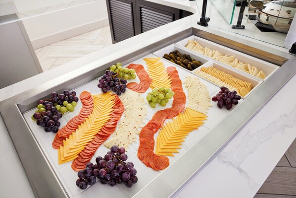 A buffet spread with various cheeses, sliced meats, and grapes. - Staybridge Suites North - Albuquerque by IHG (Albuquerque)