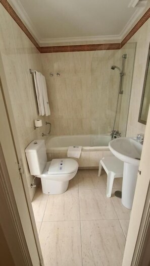 A bathroom with a toilet, bathtub, and sink. - Hotel Las Sirenas (Viveiro)