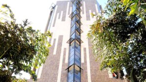 L’entrée d’un hôtel au design moderne, caractérisée par une façade verticale en verre imposante et un toit recouvert de tuiles.