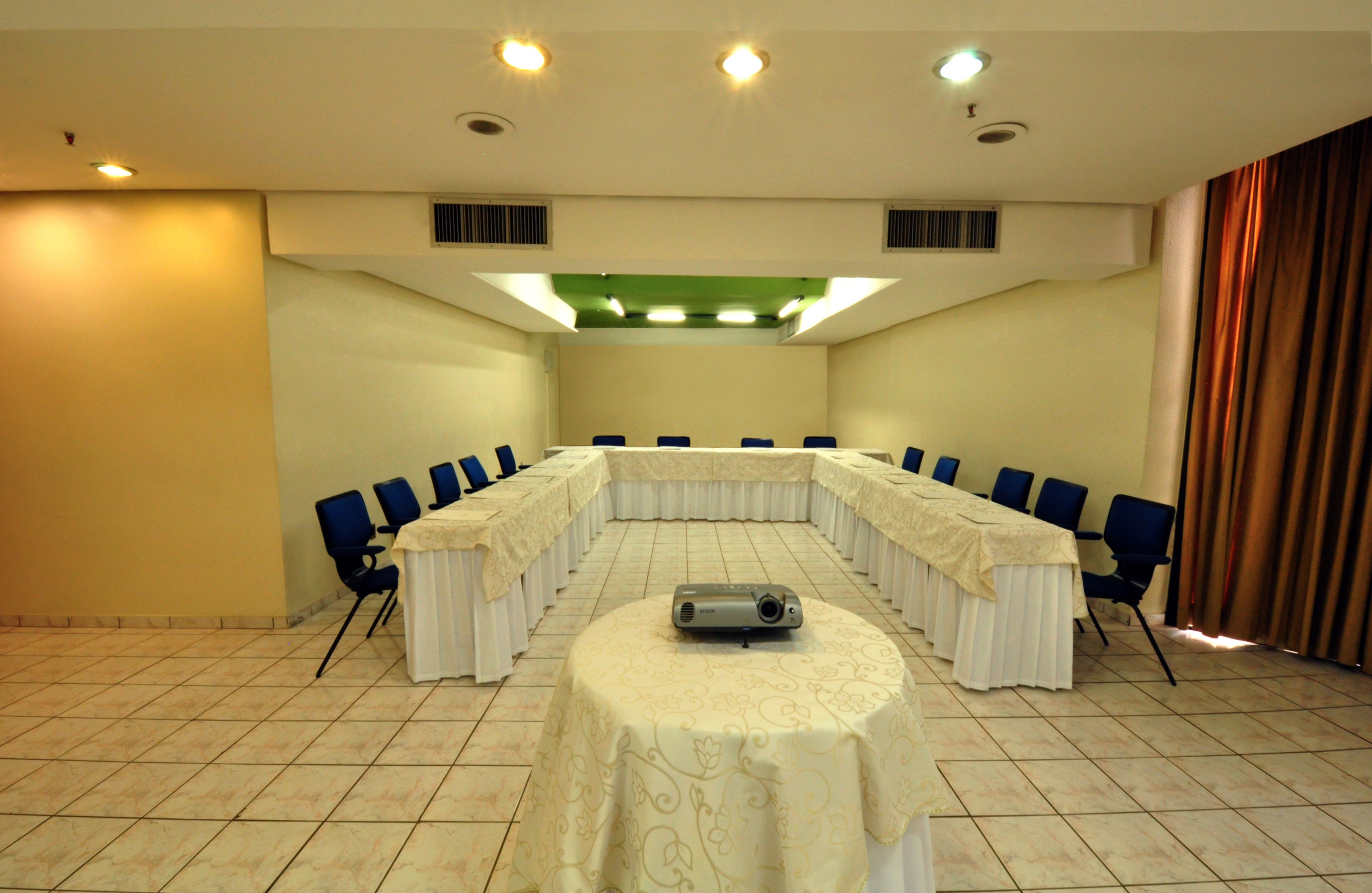 A conference room with a long table, chairs, and a projector.