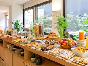 A buffet with various food items and a fruit bowl. - Mercure Milano Agrate Brianza (Agrate Brianza)
