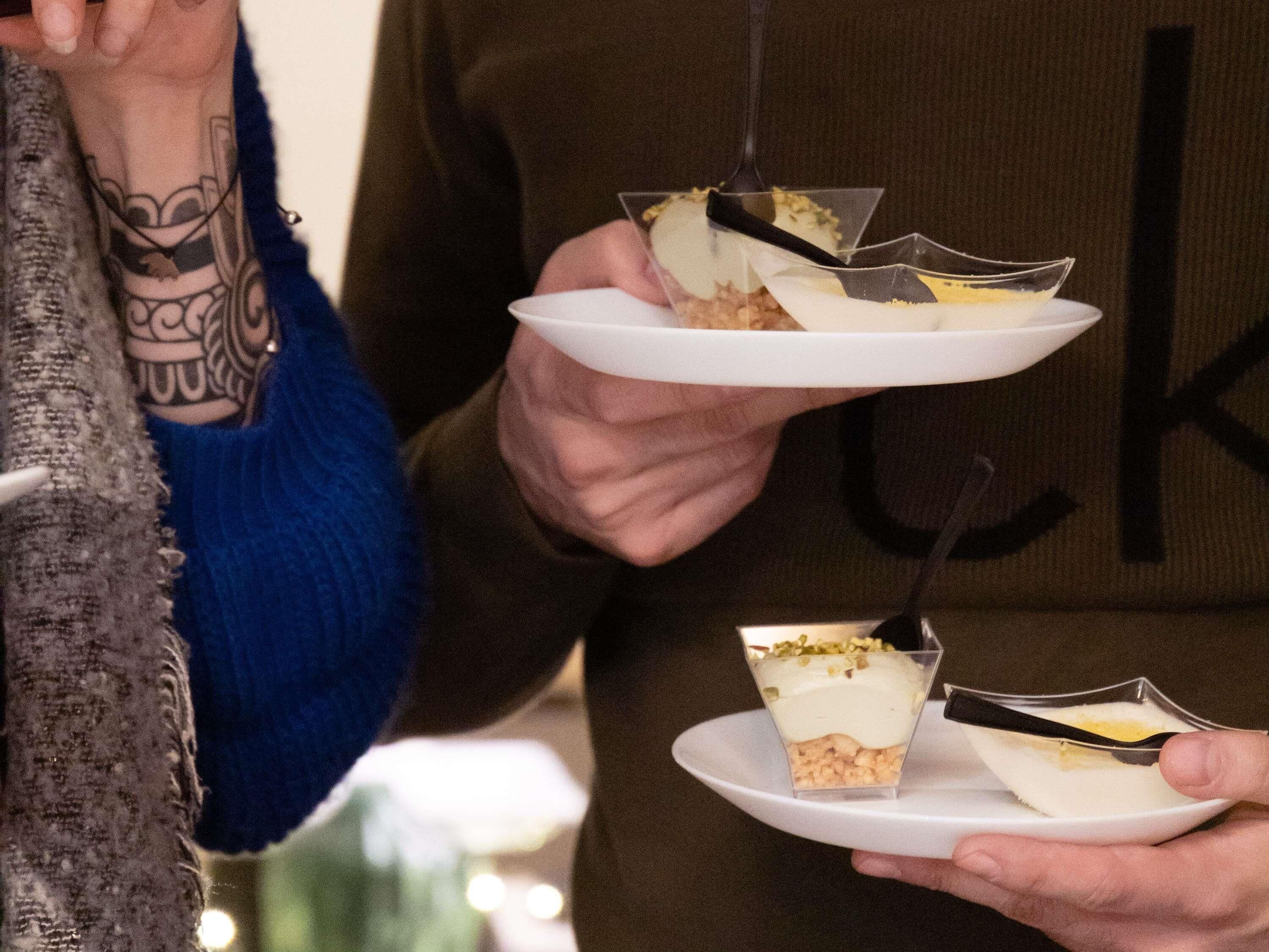 En person holder en dessert i en klar glasbeholder.