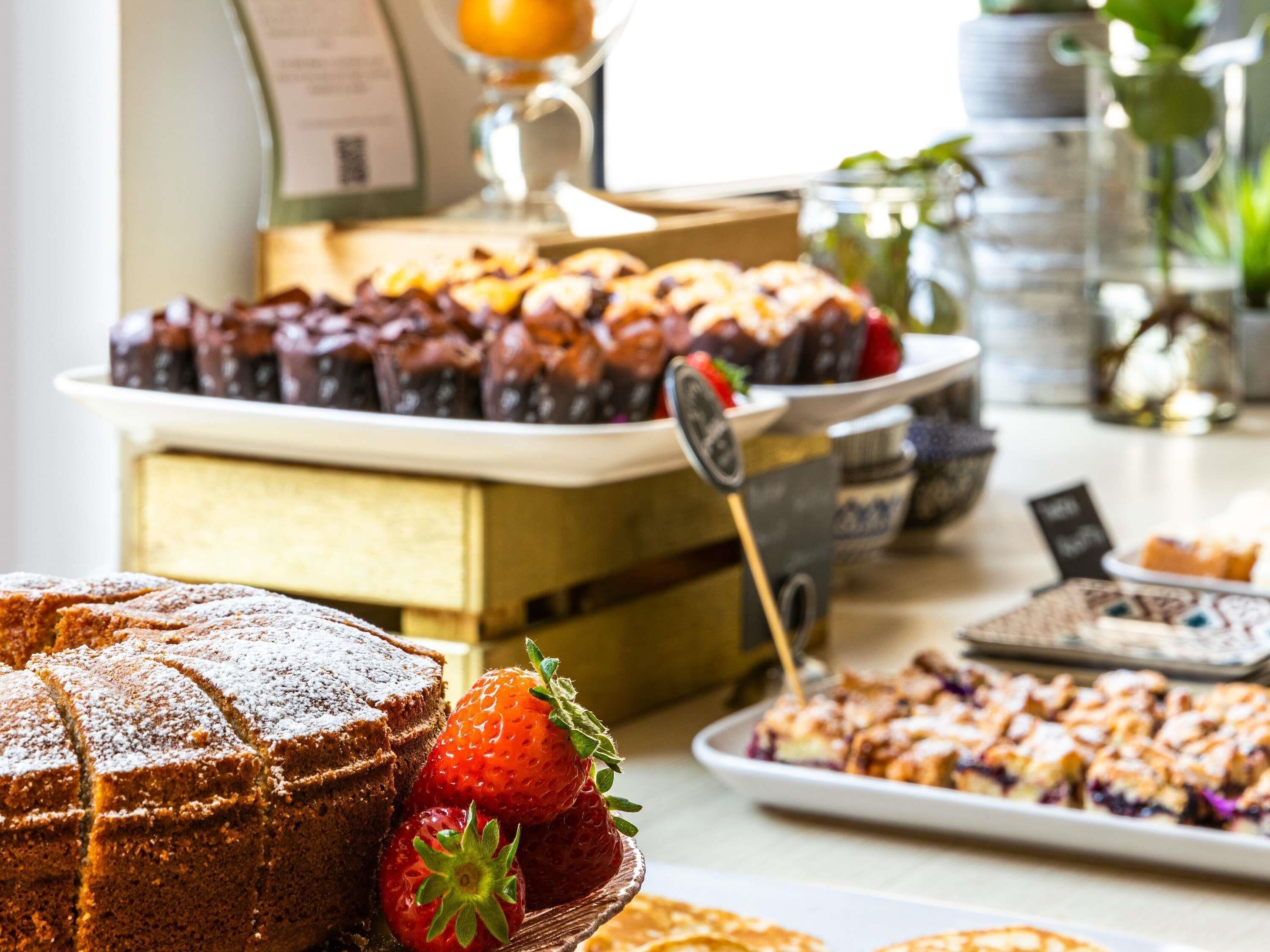 Un buffet proposant une variété de desserts, notamment des gâteaux et des fruits.