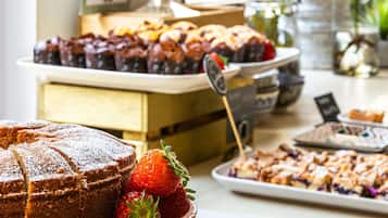 Un buffet proposant une variété de desserts, notamment des gâteaux et des fruits.