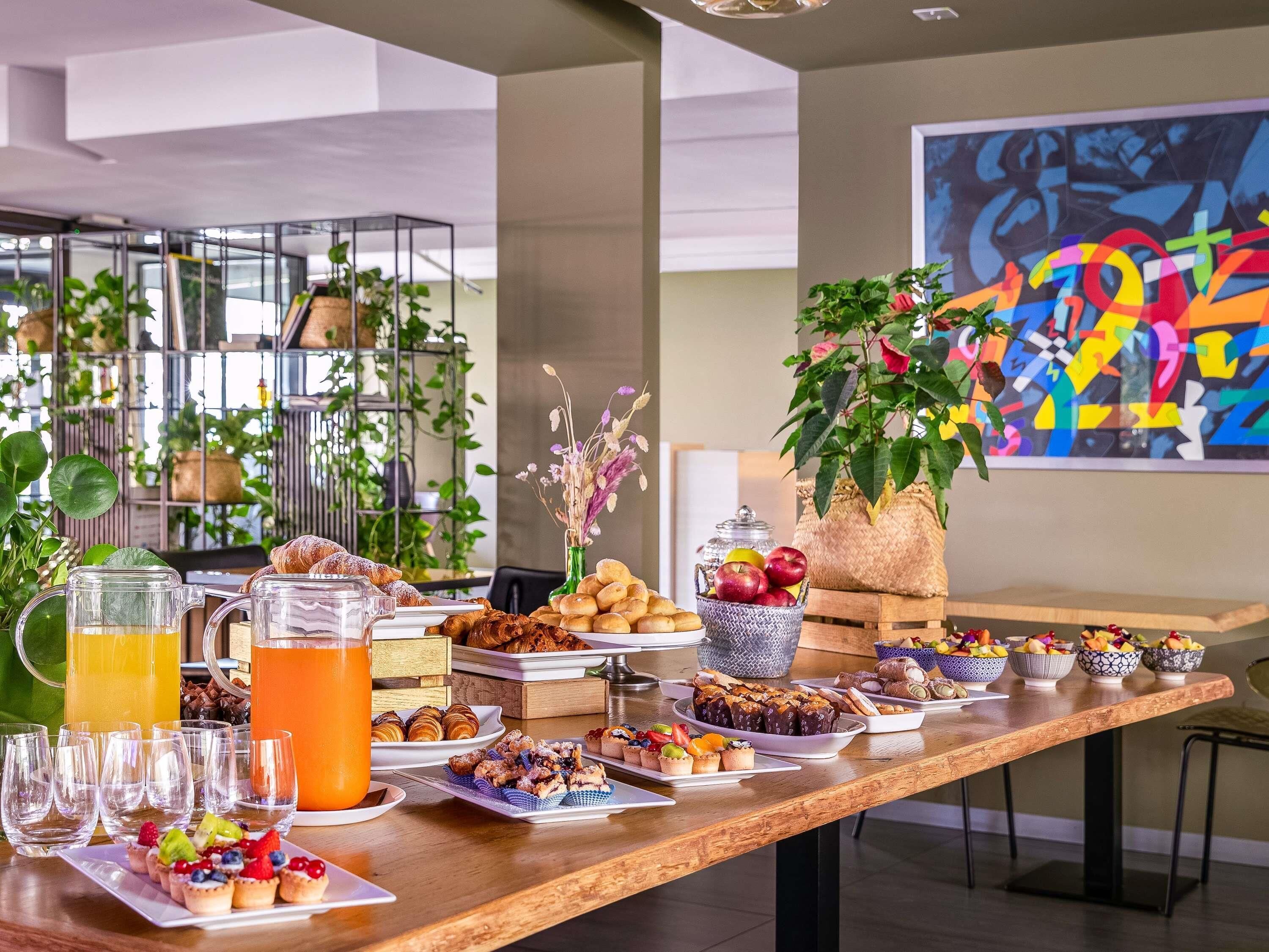 Un bufé de desayuno con diversos pasteles, frutas y bebidas.