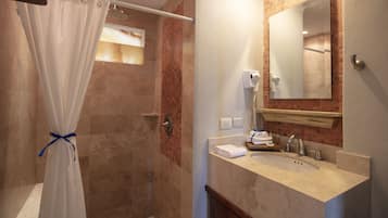 Une salle de bain avec une douche, un lavabo et un miroir.