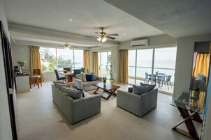 A spacious living area with a balcony, a dining area, and a kitchen.