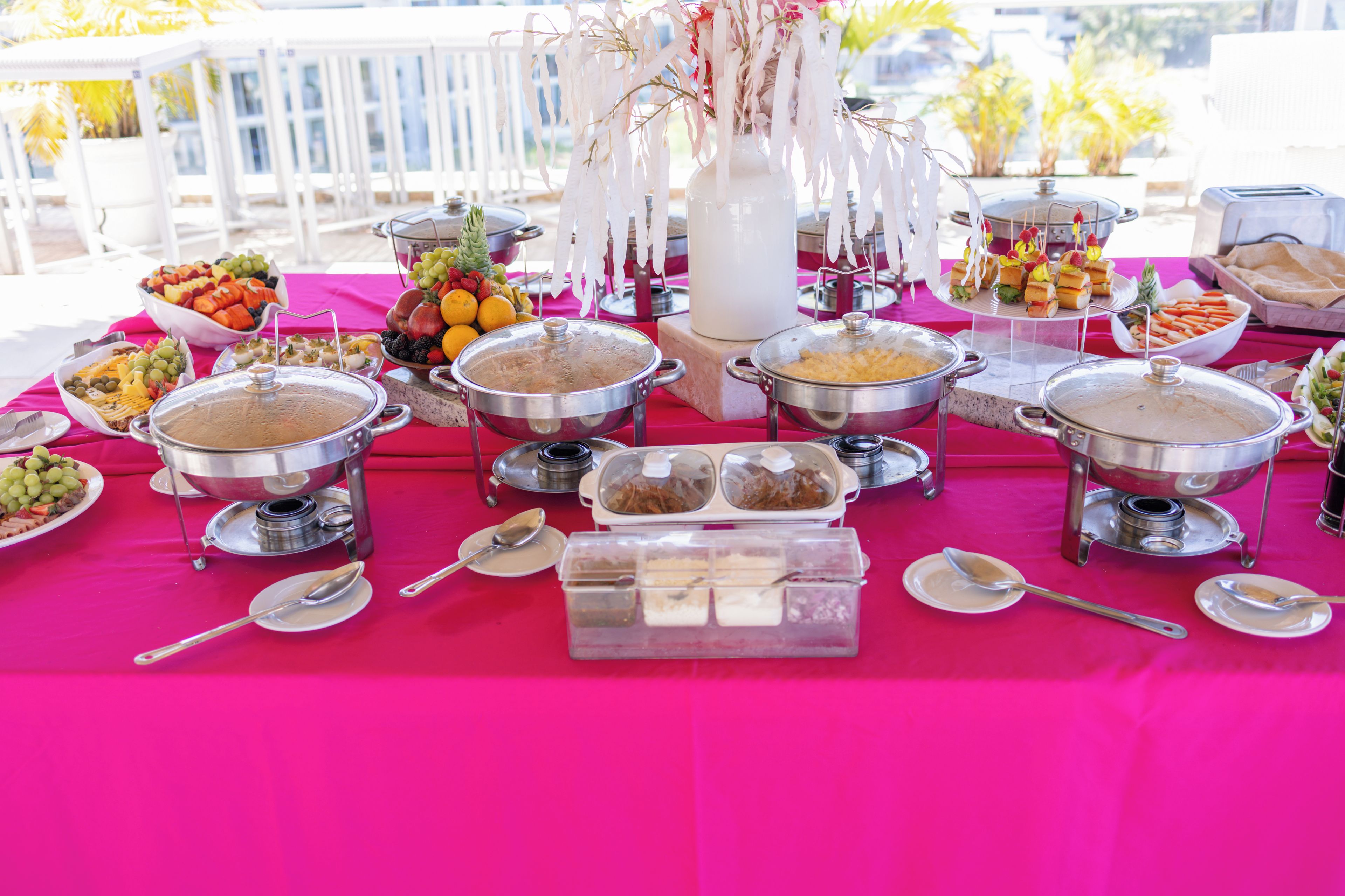 A buffet table with various food items and serving utensils.