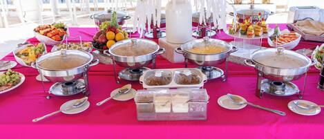 A buffet table with various food items and serving utensils.