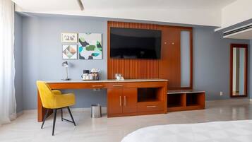 Una habitación de hotel moderna con un escritorio de madera, una silla amarilla, un televisor de pantalla plana y arte abstracto en la pared.