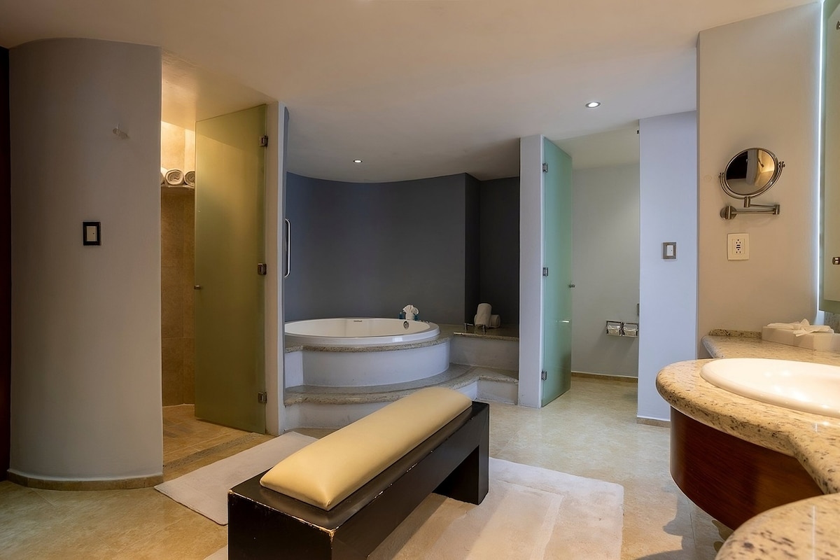 A modern bathroom with a freestanding bathtub, a bench, and a vanity with a mirror.