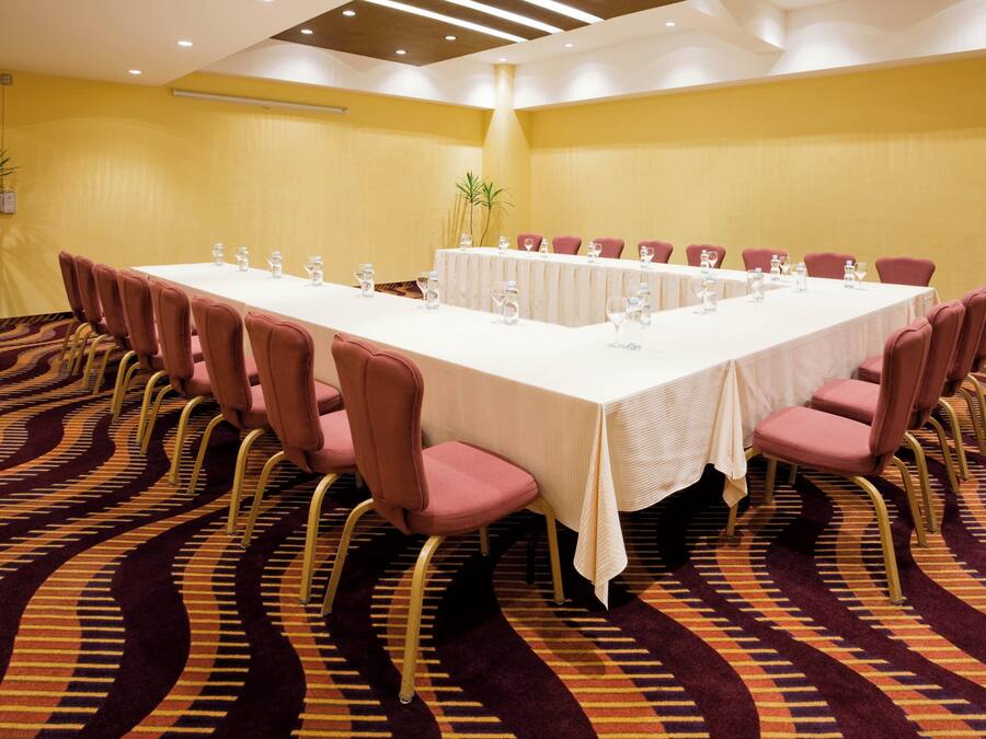 A conference room with a long table, multiple chairs, and water bottles.
