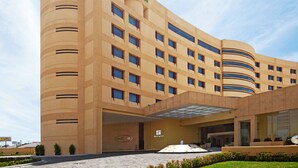 A modern Holiday Inn hotel with a curved facade, multiple windows, and a central entrance with a canopy.