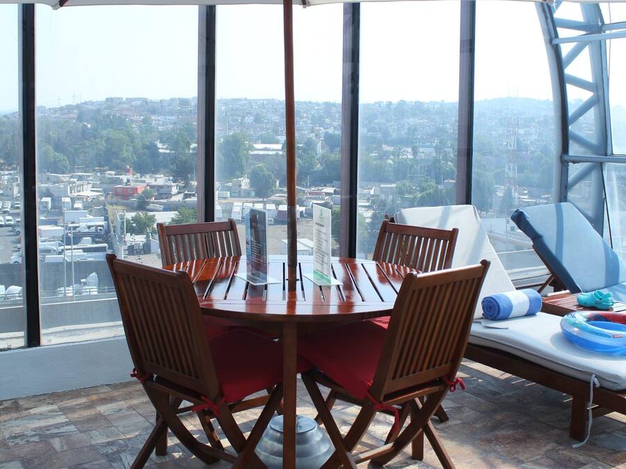 A dining area with a table, chairs, and a white umbrella.