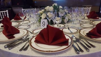 Une table dressée pour un dîner formel, avec des marque-places numérotés, des couverts et des verres à vin.
