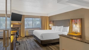 A hotel room with a large bed, a desk with a chair, a TV, and a window with curtains. - Best Western Plus McCall Lodge & Suites (McCall)