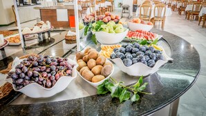 A buffet with various fruits and pastries.