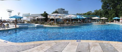 Una piscina al aire libre de temporada, sombrillas