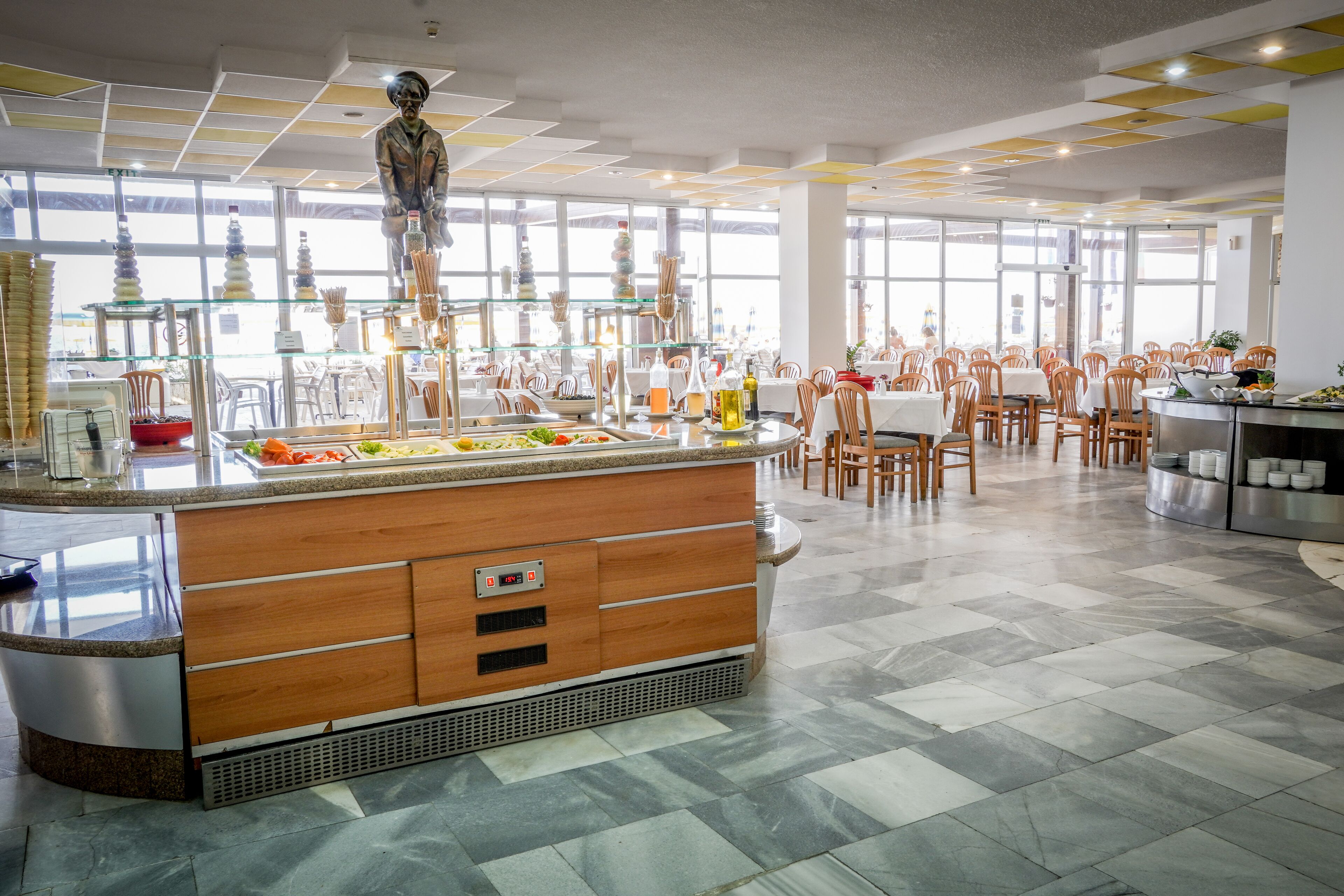 A spacious dining area with a central island, multiple tables, and chairs.
