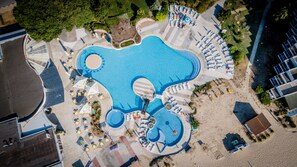 Una piscina al aire libre de temporada, sombrillas