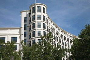 Un edificio de varios pisos con fachada curva, ventanas amplias y balcones.