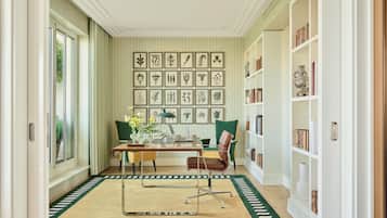 A well-lit room with a dining table, chairs, a laptop, and a bookshelf.