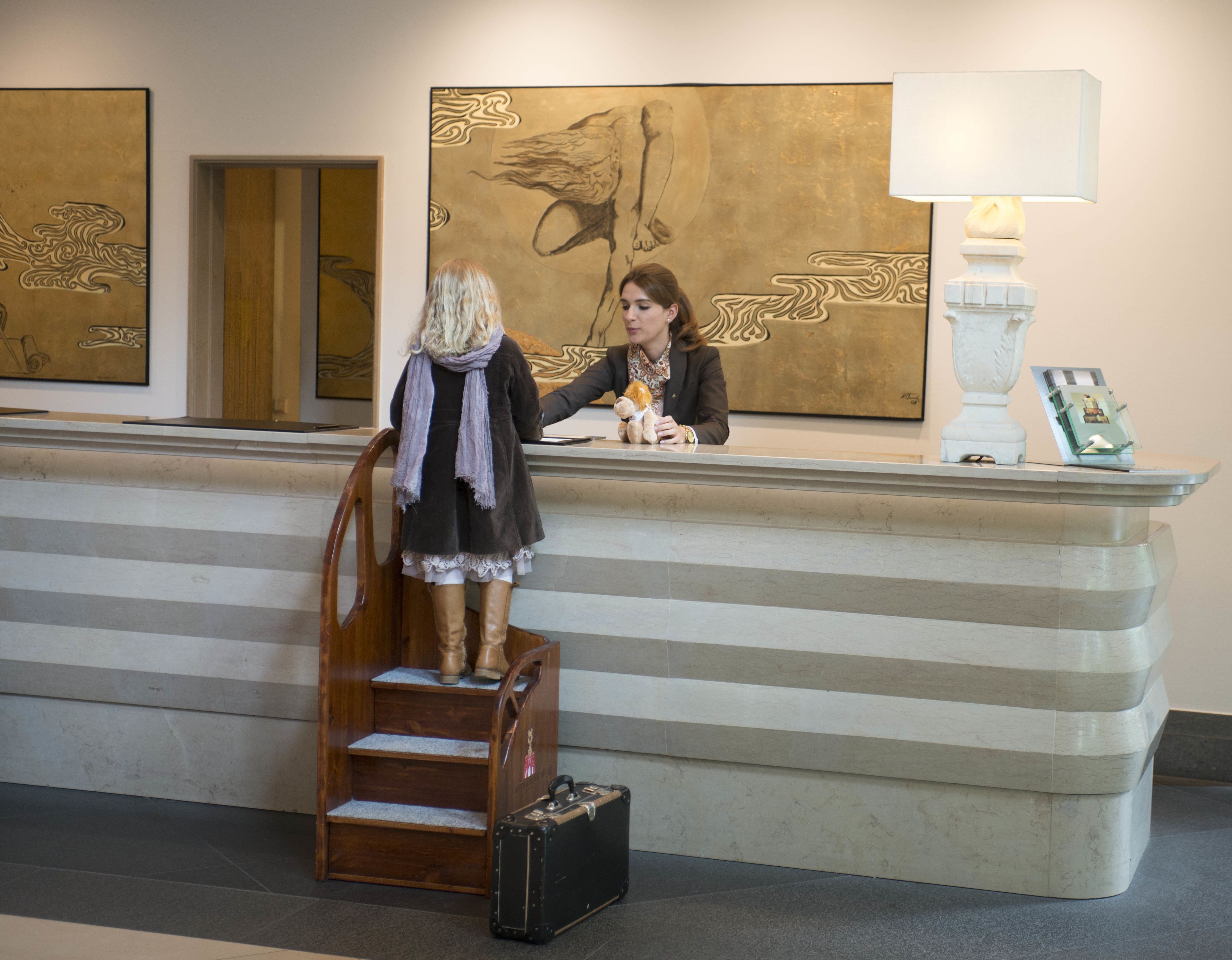 A reception desk with a wooden chair and a suitcase.