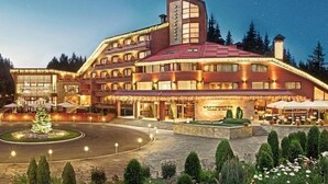 Un hotel gran de diverses plantes amb una entrada destacada i un pati paisatjistic.