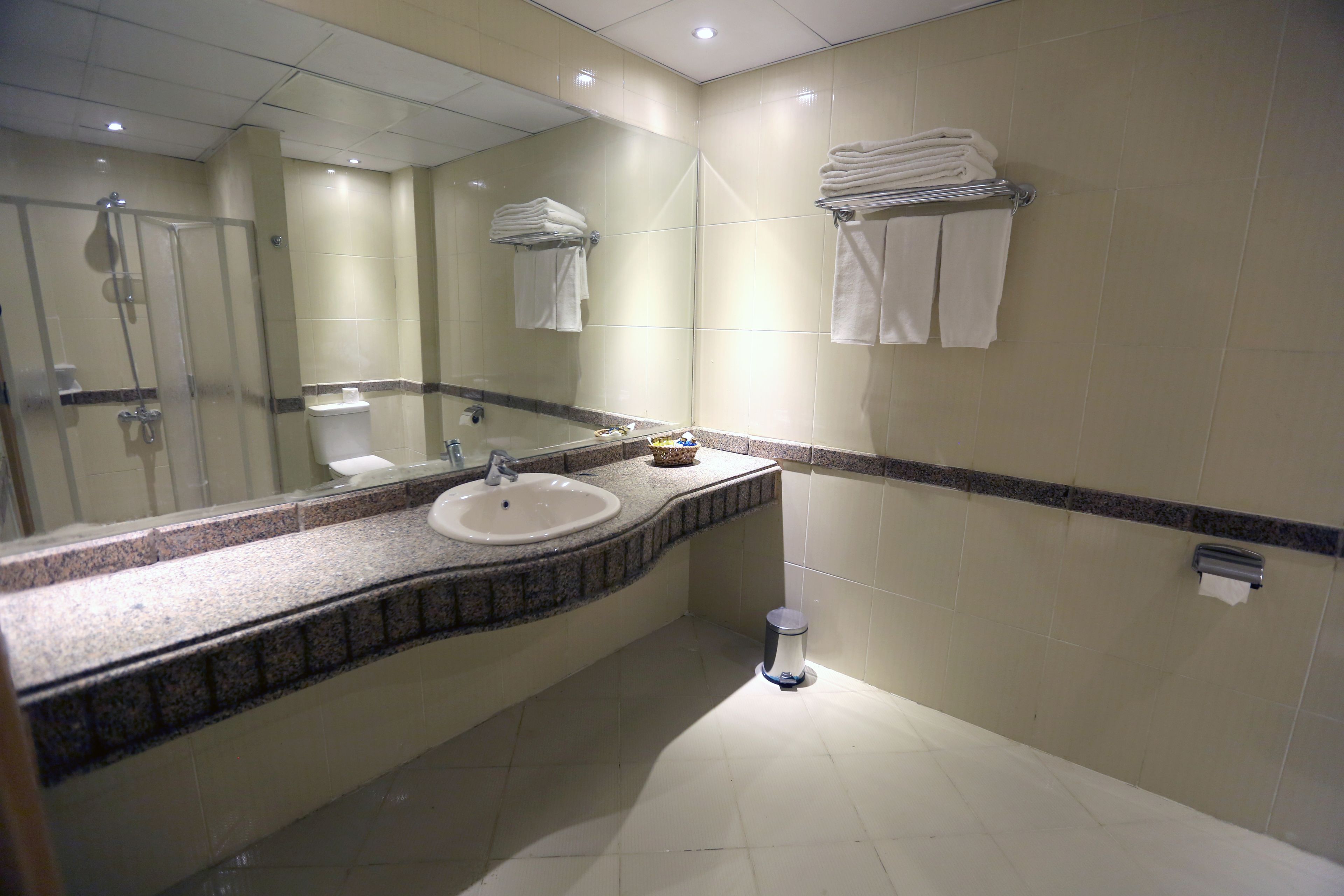A bathroom with a sink, mirror, and towel rack.