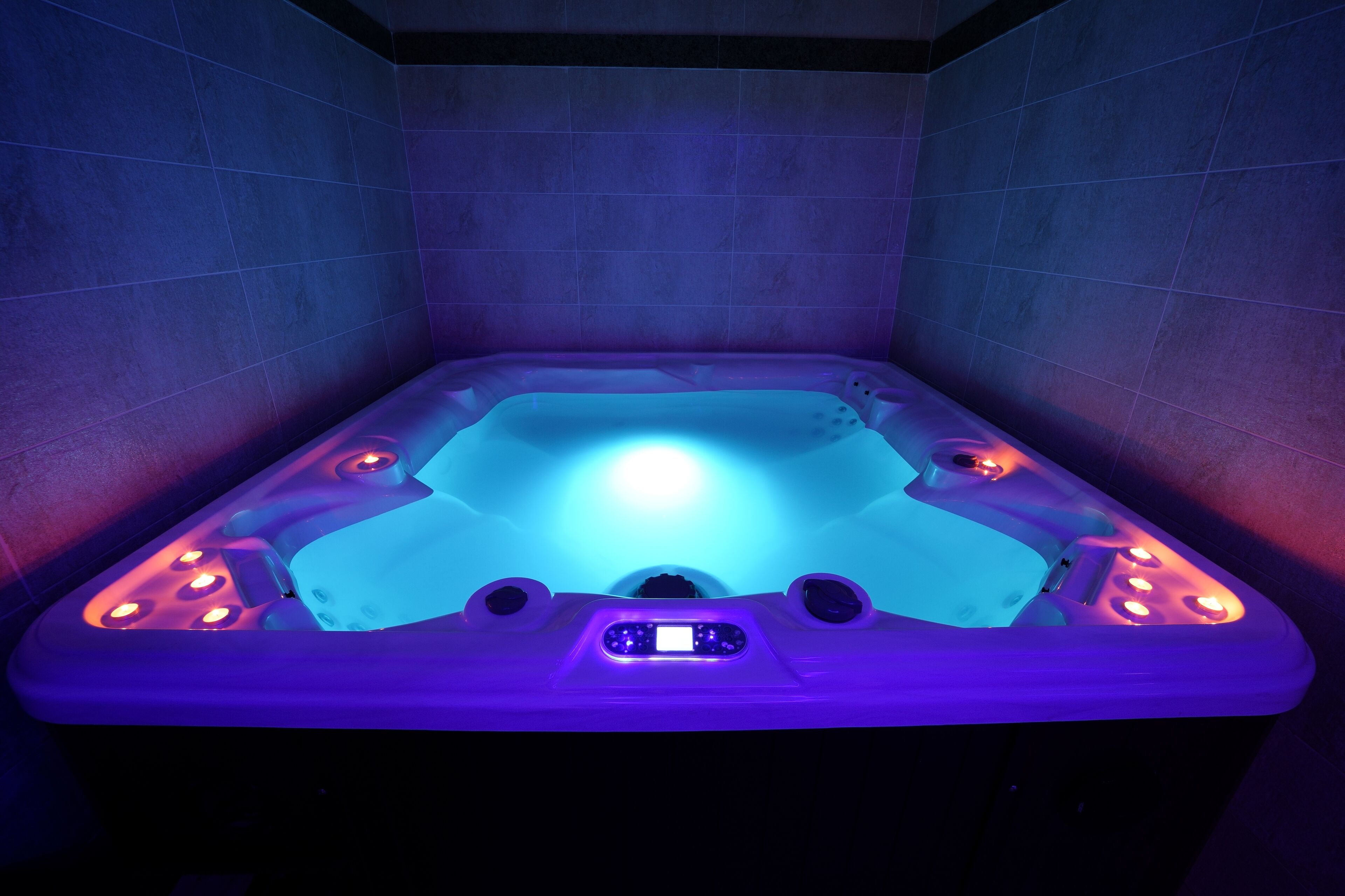 A hot tub with LED lighting and control panel.