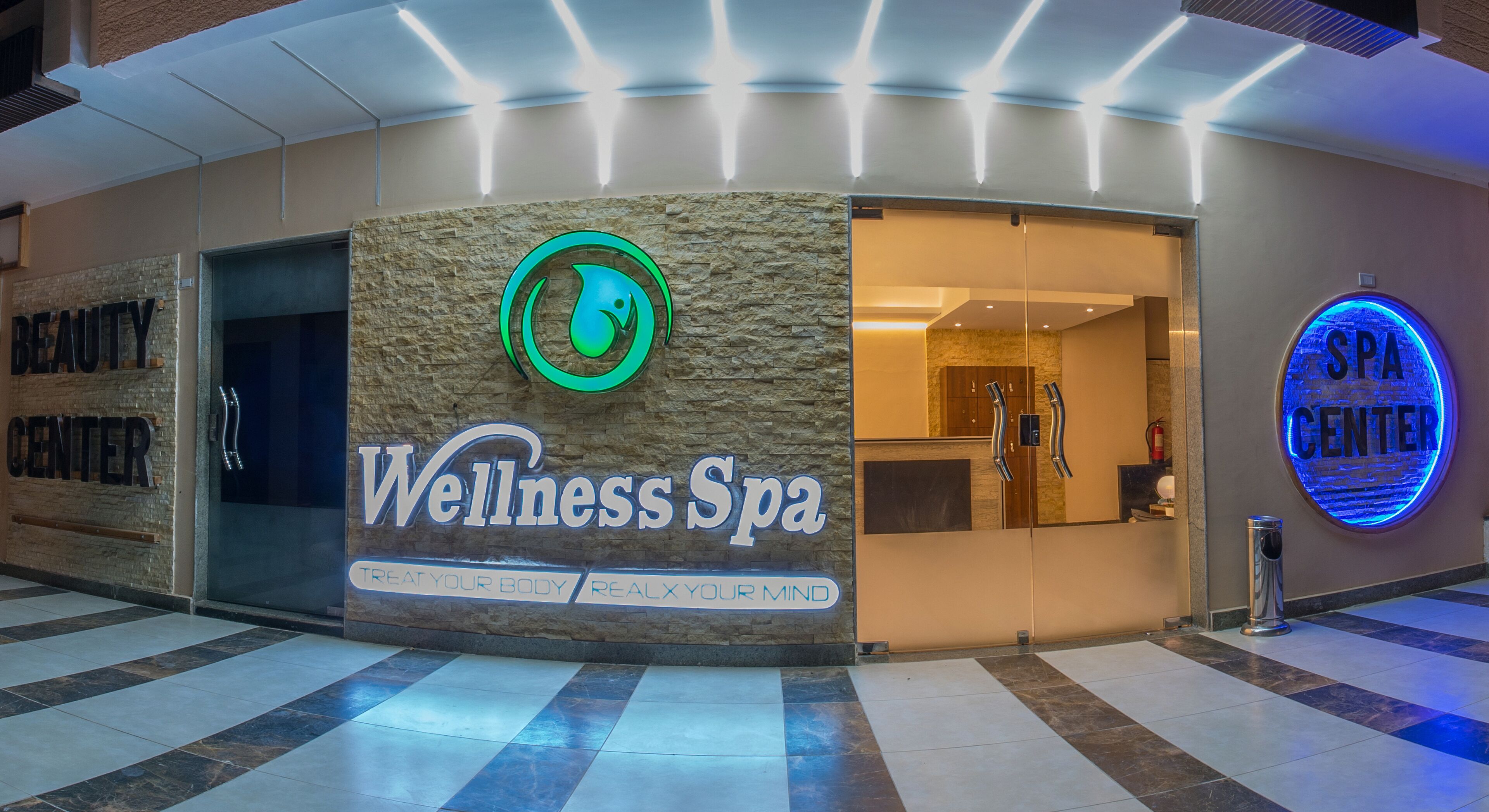 Een wellness spa met een gevel van steen, een neonreclame en een bord met spa-informatie.
