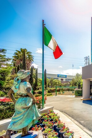 A statue of a woman in a green dress with a flagpole behind her.