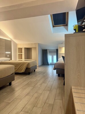 A modern hotel room with two beds, a skylight, and a wooden floor. - Hotel Miramonti (Turin)