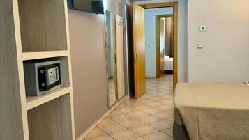 A hotel room with a bed, a wardrobe, a mirror, and a television.