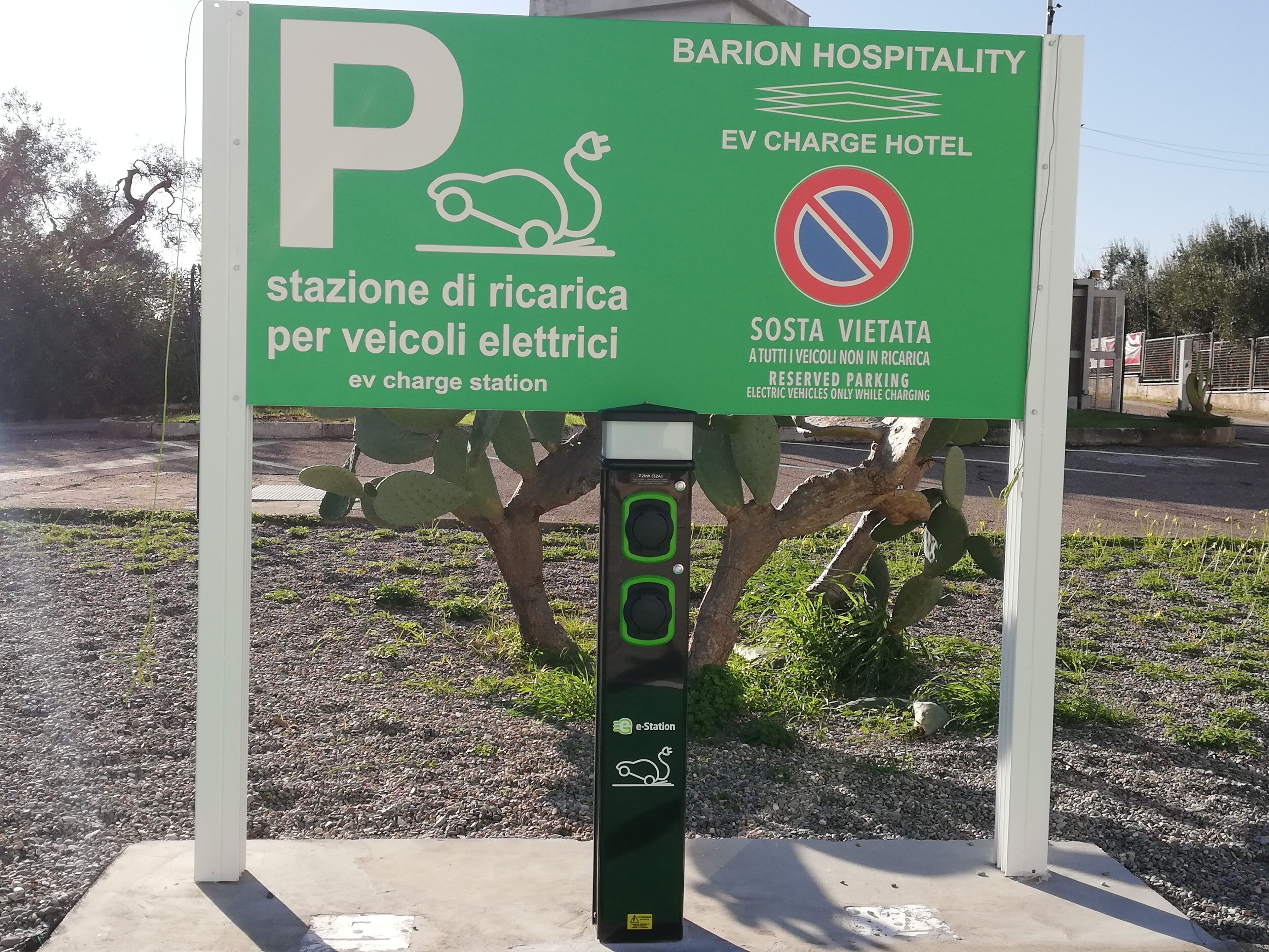 Een parkeerbord voor een laadstation voor elektrische voertuigen bij BARION HOSPITALITY.