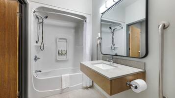 A modern bathroom with a bathtub, a sink, a mirror, and a shower.