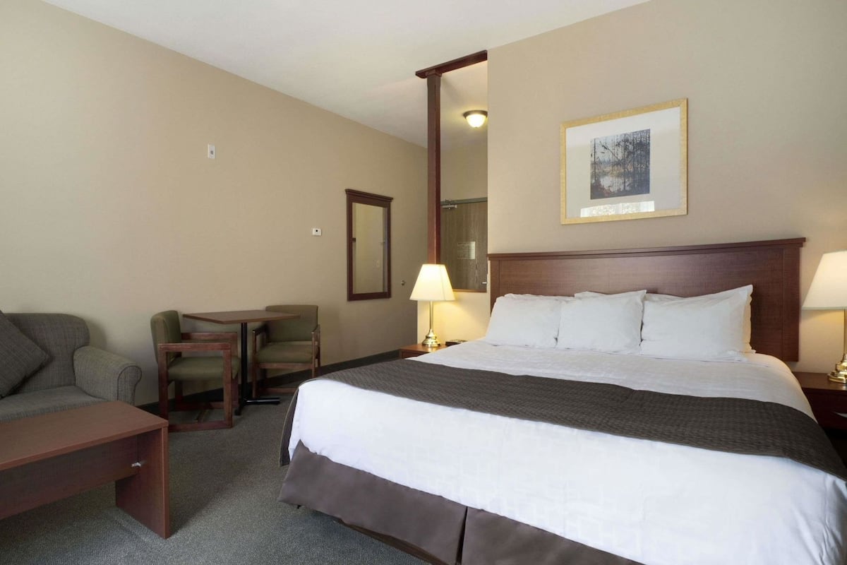 Une chambre d’hôtel avec un grand lit, un bureau, une chaise et un canapé.
