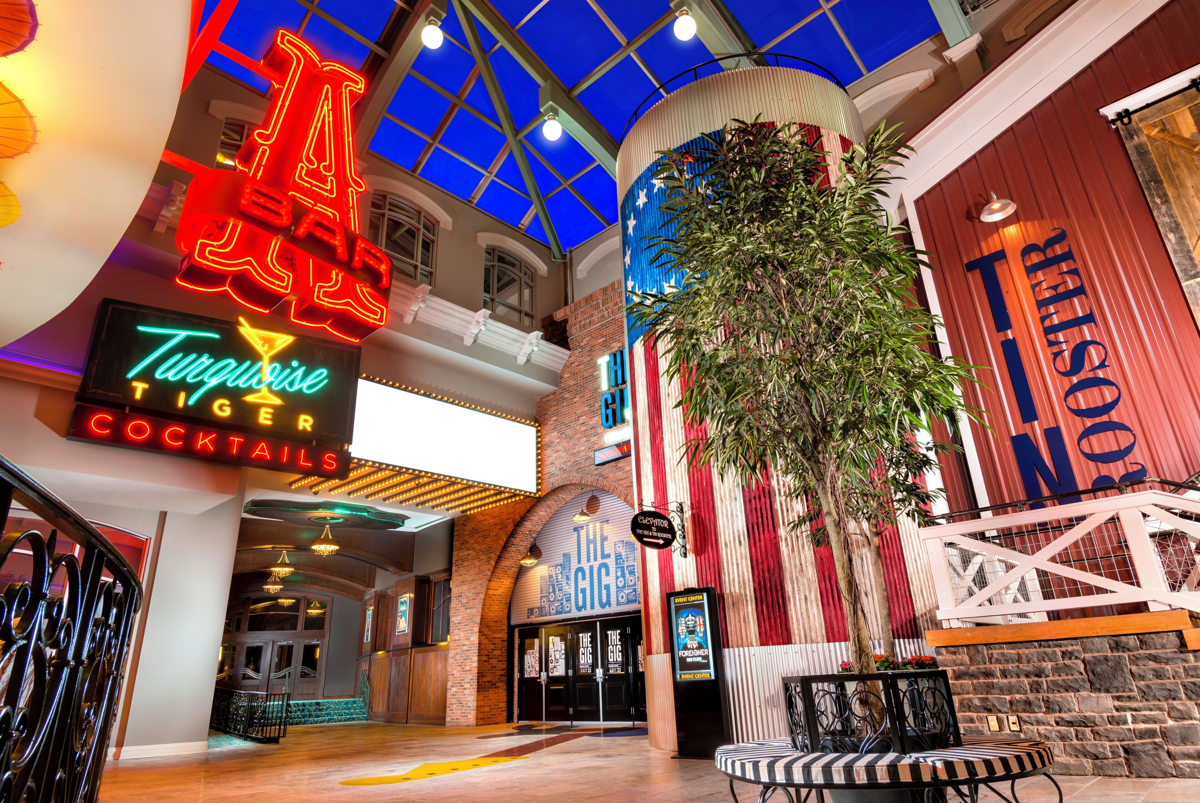 A spacious atrium with a high ceiling, a bar area, and a seating area with a large plant.