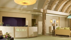 A reception area with a reception desk, seating area, and a large window.