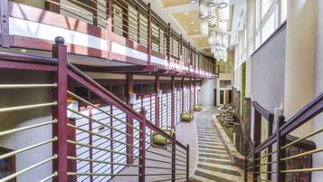 A multi-level interior with a wooden staircase, a mezzanine, and a curved walkway.