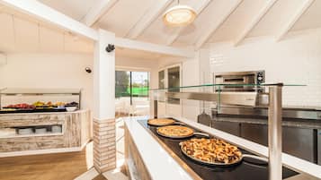 A kitchen with a buffet area, a glass railing, and a view of the outdoors.