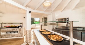 A kitchen with a buffet area, a glass railing, and a view of the outdoors. - Globales Samoa (Manacor)