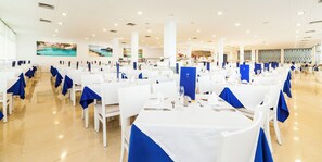 A spacious banquet hall with white tables and chairs, blue tablecloths, and a polished floor. - Globales Samoa (Manacor)