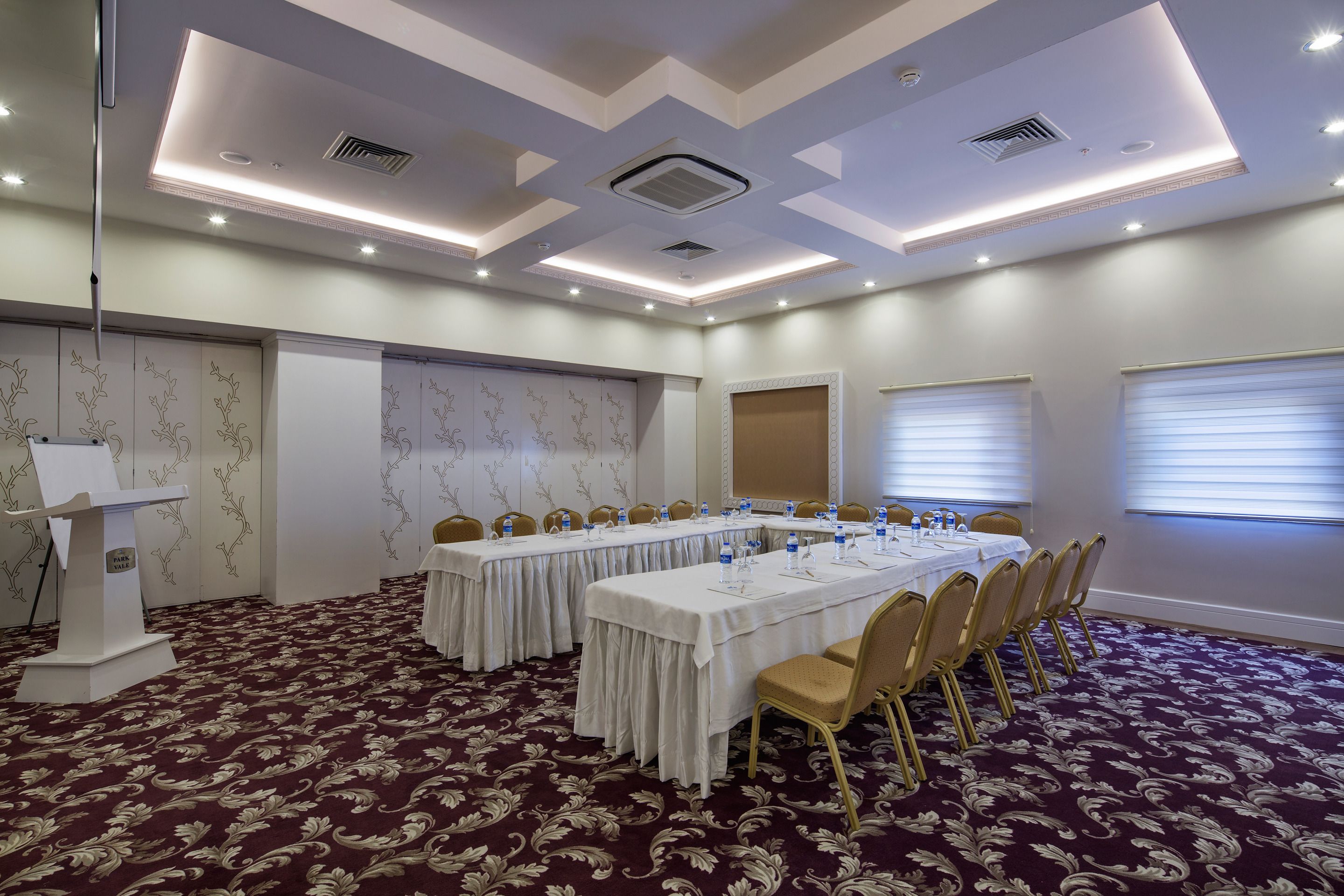 A conference room with a long table, chairs, and a podium.