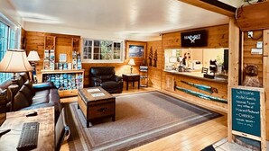 A cozy hotel lobby with a reception desk, seating area, and a large painting above the office.