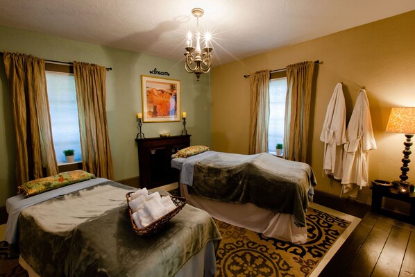 A hotel room with two beds, a chandelier, a painting, and a patterned rug. - Strawberry Valley Inn (Mount Shasta)