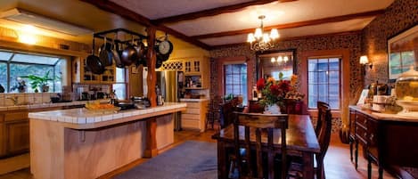 A spacious kitchen with a central island, wooden cabinets, and a dining area with a table and chairs.