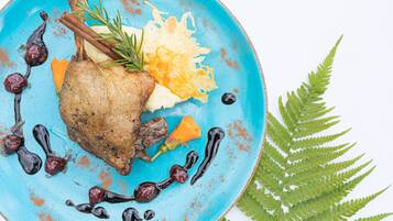 Ein Teller mit gebratenem Fleisch, Gemüse und Soße.