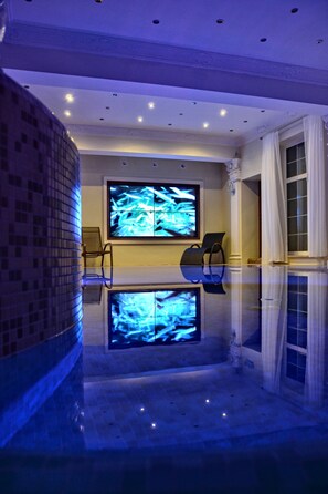 Una piscina techada, sillones reclinables de piscina